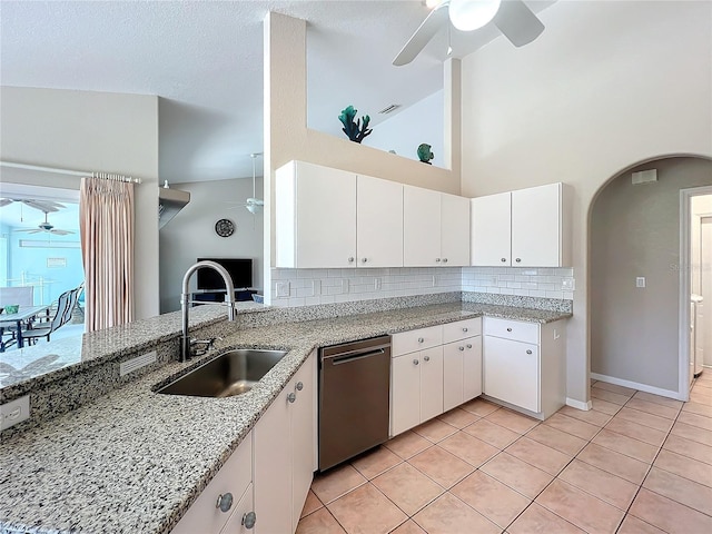 kitchen with decorative backsplash, ceiling fan, arched walkways, dishwasher, and a sink
