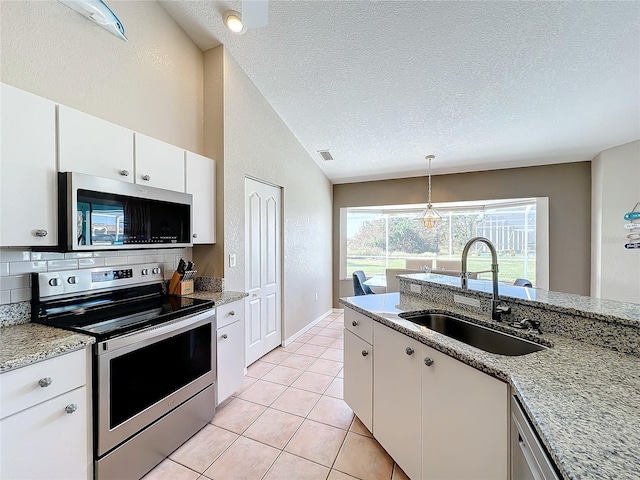 kitchen with lofted ceiling, sink, white cabinets, appliances with stainless steel finishes, and a textured ceiling