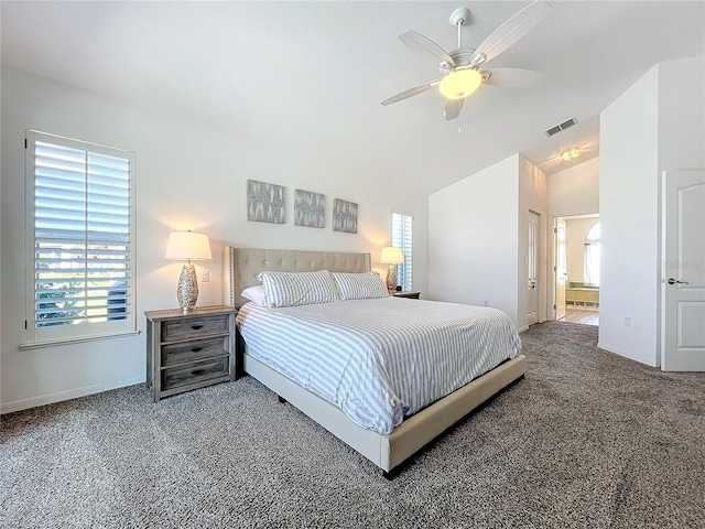 carpeted bedroom with lofted ceiling, ceiling fan, and ensuite bath