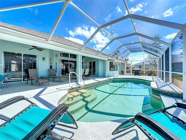 outdoor pool featuring a patio, ceiling fan, and glass enclosure