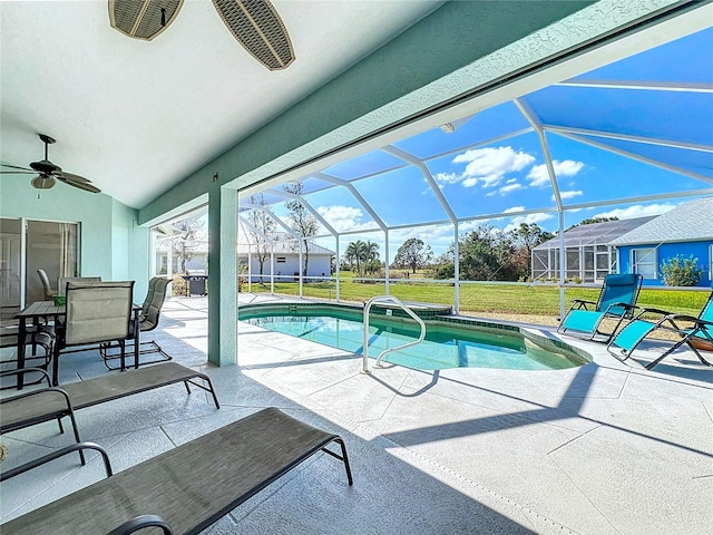 outdoor pool with a patio, a ceiling fan, a lawn, and a lanai