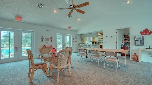 carpeted dining room with lofted ceiling, french doors, a textured ceiling, and ceiling fan