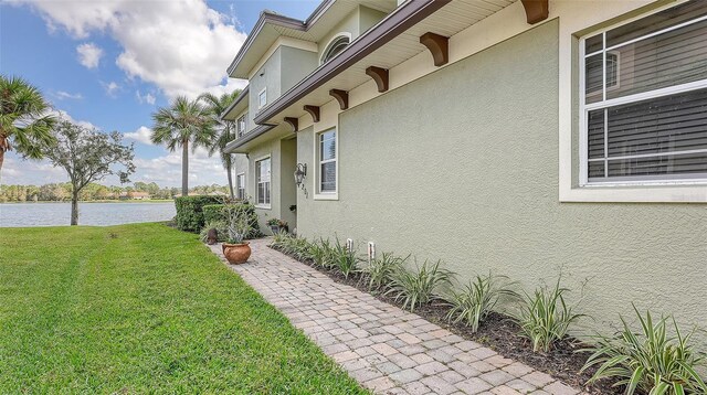 view of property exterior featuring a yard and a water view