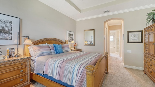 carpeted bedroom with ensuite bath and crown molding