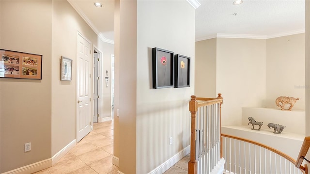 corridor with ornamental molding, a textured ceiling, and light tile patterned floors