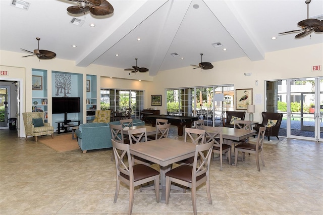 dining space with beam ceiling, a high ceiling, and light tile patterned floors