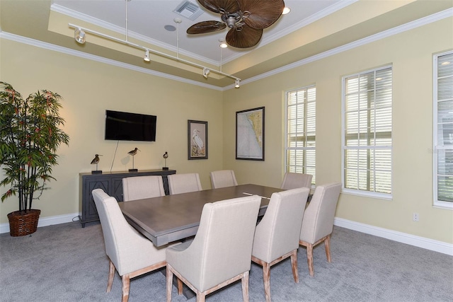 dining area with crown molding, light carpet, a tray ceiling, and ceiling fan