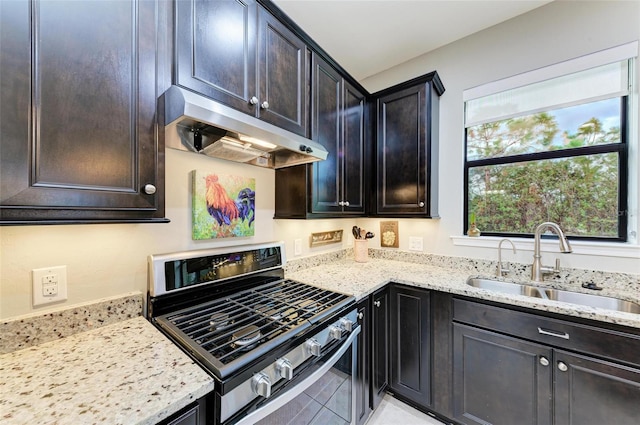 kitchen with sink, light stone counters, and gas stove