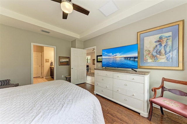 bedroom featuring hardwood / wood-style floors, ceiling fan, and ensuite bath