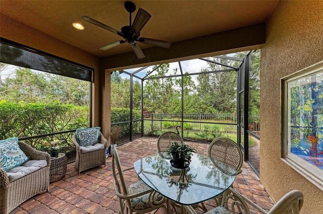 sunroom / solarium featuring ceiling fan