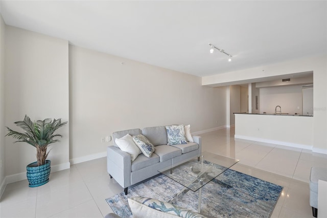 living room featuring track lighting, sink, and tile patterned flooring