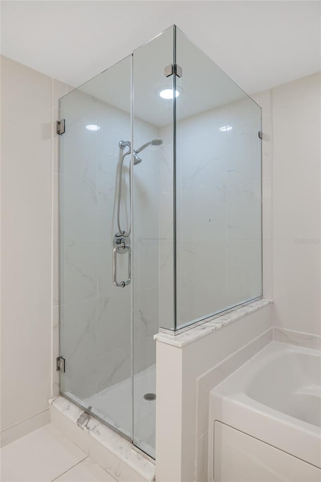 bathroom featuring shower with separate bathtub and tile patterned flooring