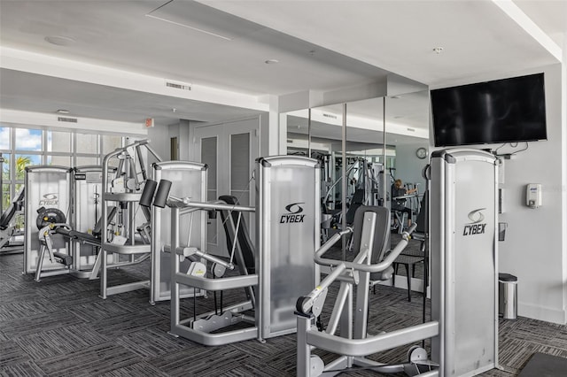 exercise room featuring dark carpet