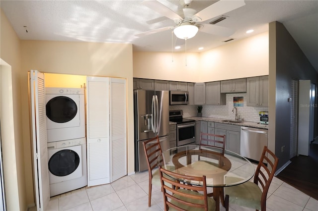 4105 33rd Avenue Dr W Unit 4105, Bradenton, FL 34205 - kitchen featuring stacked washer / drying machine, a sink, stainless steel appliances, light tile patterned floors, and gray cabinets