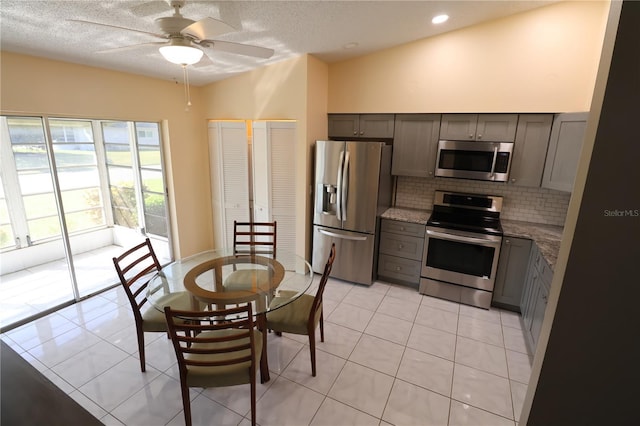4105 33rd Avenue Dr W Unit 4105, Bradenton, FL 34205 - kitchen featuring light tile patterned floors, ceiling fan, backsplash, gray cabinetry, and appliances with stainless steel finishes
