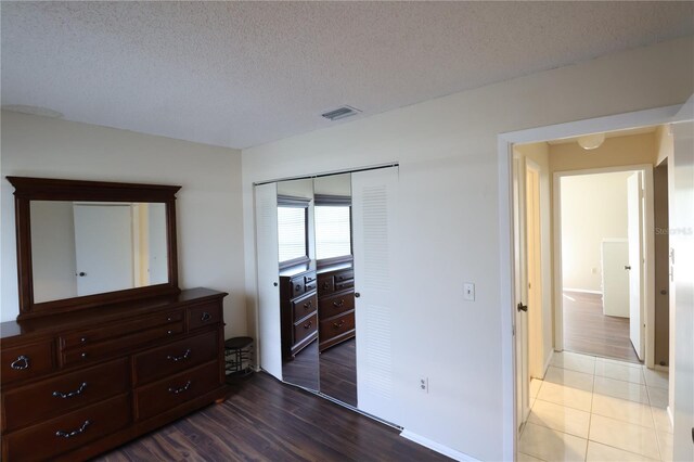 bedroom featuring a textured ceiling, wood-type flooring, and a closet