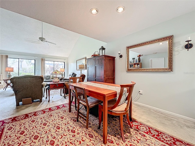 dining room with ceiling fan, light carpet, and lofted ceiling