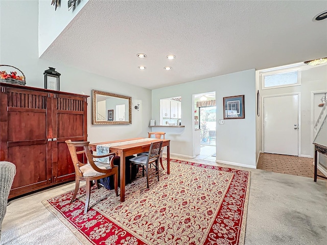 dining area with light carpet and a textured ceiling