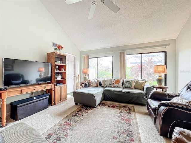 living room featuring light carpet, a textured ceiling, high vaulted ceiling, and ceiling fan