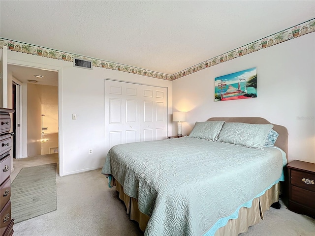 carpeted bedroom featuring a textured ceiling and a closet