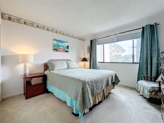 bedroom featuring light carpet and a textured ceiling