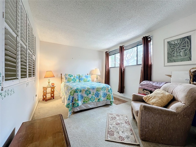 bedroom featuring light carpet and a textured ceiling