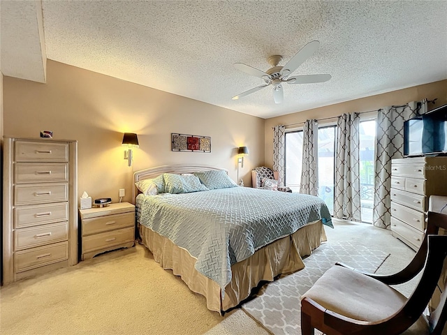 carpeted bedroom with a textured ceiling, access to outside, and ceiling fan