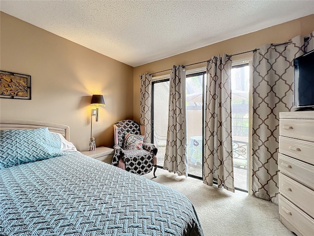 carpeted bedroom with access to outside and a textured ceiling