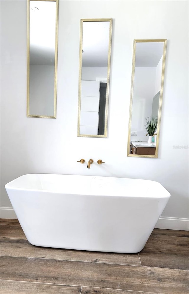 bathroom featuring hardwood / wood-style flooring and a tub