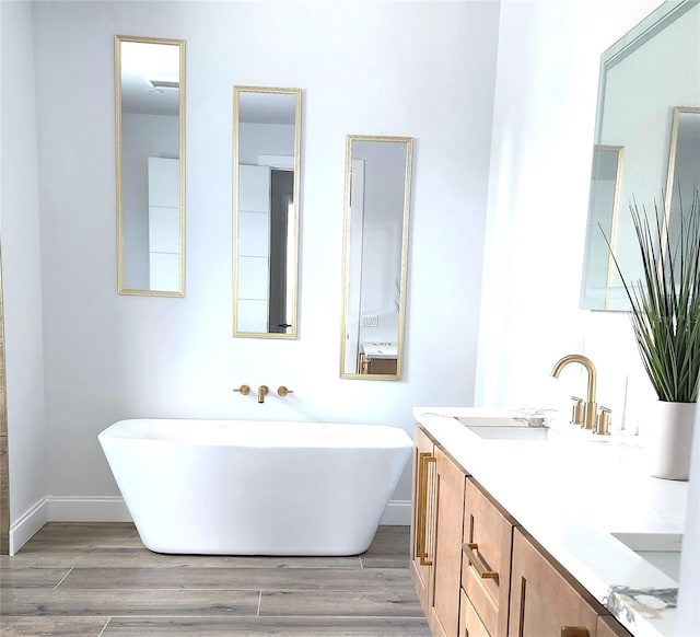 bathroom with vanity, a tub to relax in, and hardwood / wood-style floors