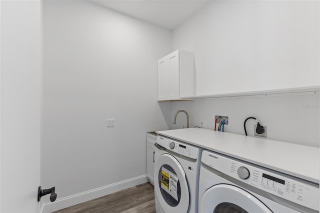 clothes washing area featuring cabinets, separate washer and dryer, and dark hardwood / wood-style flooring