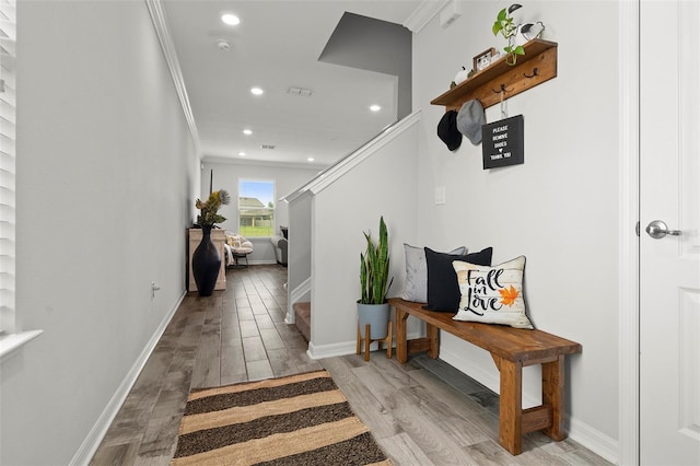 corridor featuring crown molding and light hardwood / wood-style floors