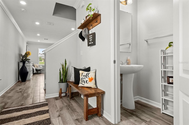 interior space with ornamental molding, sink, and hardwood / wood-style flooring