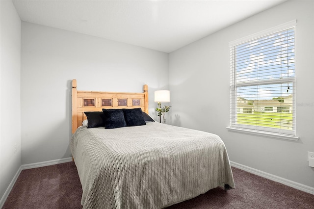 bedroom with multiple windows and dark carpet