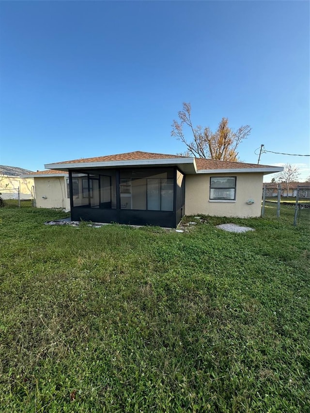 back of house with a sunroom and a yard