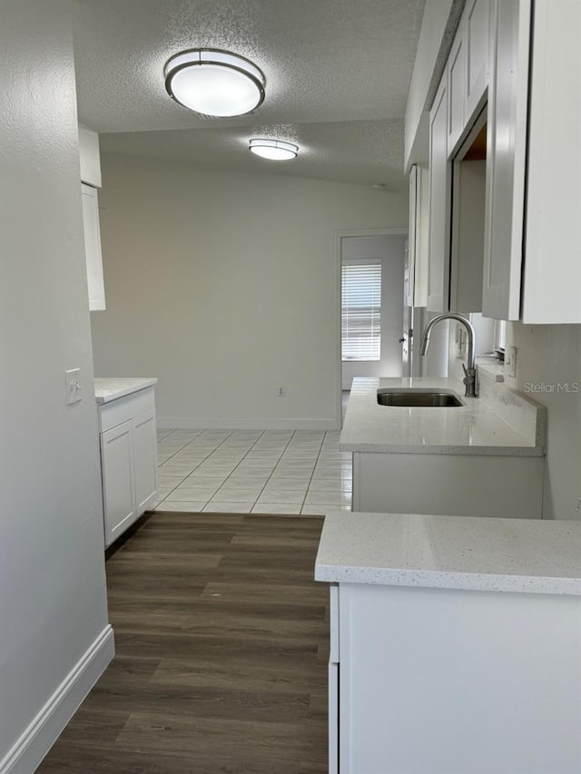 kitchen featuring white cabinets, a textured ceiling, sink, and dark hardwood / wood-style flooring