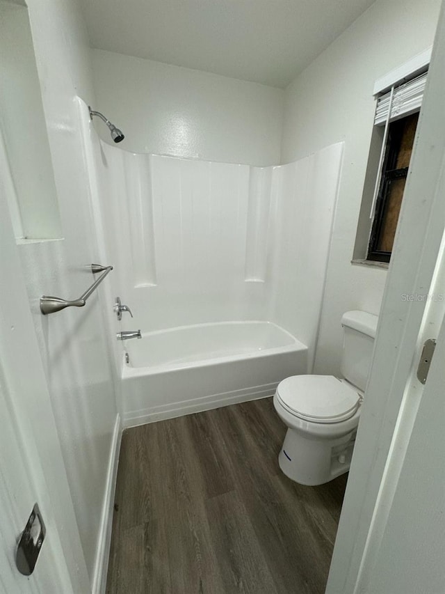 bathroom featuring shower / washtub combination, wood-type flooring, and toilet