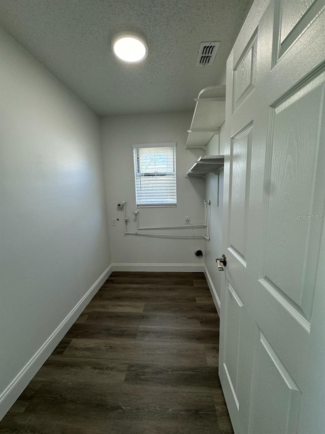 washroom featuring washer hookup, dark hardwood / wood-style floors, and a textured ceiling