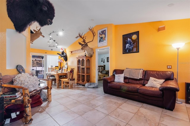 living room featuring light tile patterned floors and vaulted ceiling