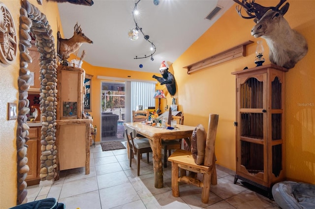 tiled dining room with vaulted ceiling