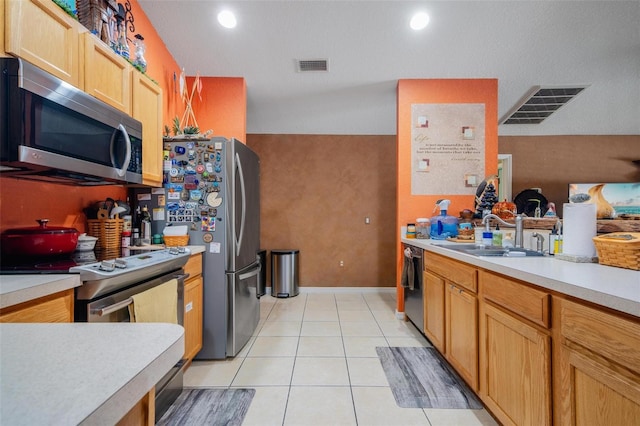 kitchen featuring stainless steel appliances, sink, and light tile patterned flooring