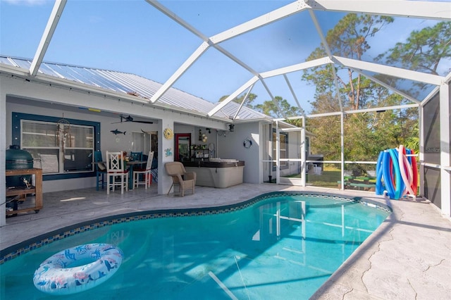 view of pool featuring a patio area, glass enclosure, and ceiling fan