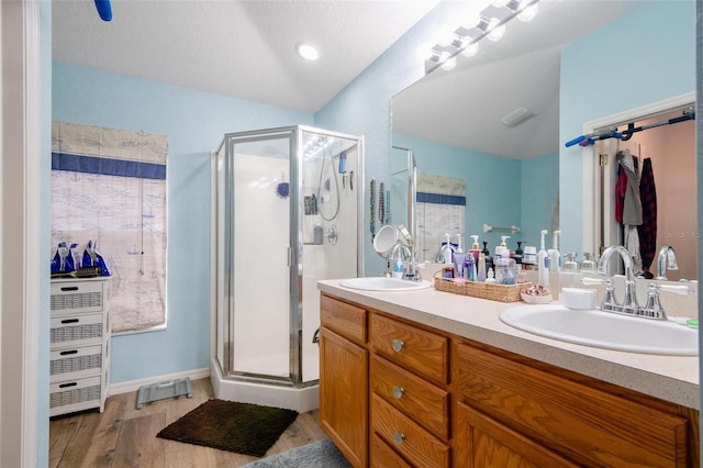 bathroom with a shower with door, vanity, a textured ceiling, and hardwood / wood-style flooring