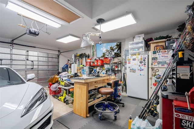 garage featuring white fridge, a workshop area, and a garage door opener