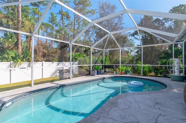 view of swimming pool with a patio area and a lanai