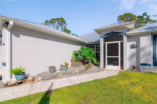 view of exterior entry with a lawn