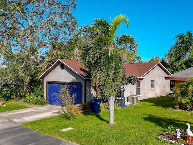 view of front facade with driveway, an attached garage, central AC unit, and a front yard