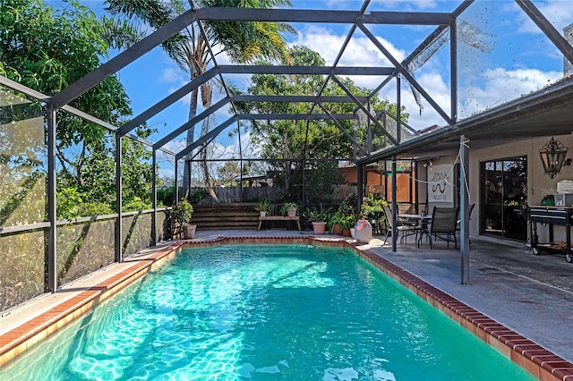 view of pool with a patio and glass enclosure