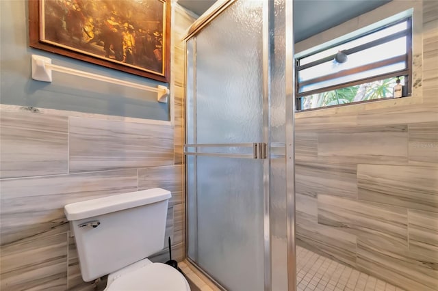 full bathroom with a stall shower, tile walls, and toilet