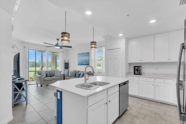 kitchen featuring a center island with sink, sink, white cabinets, and a wealth of natural light